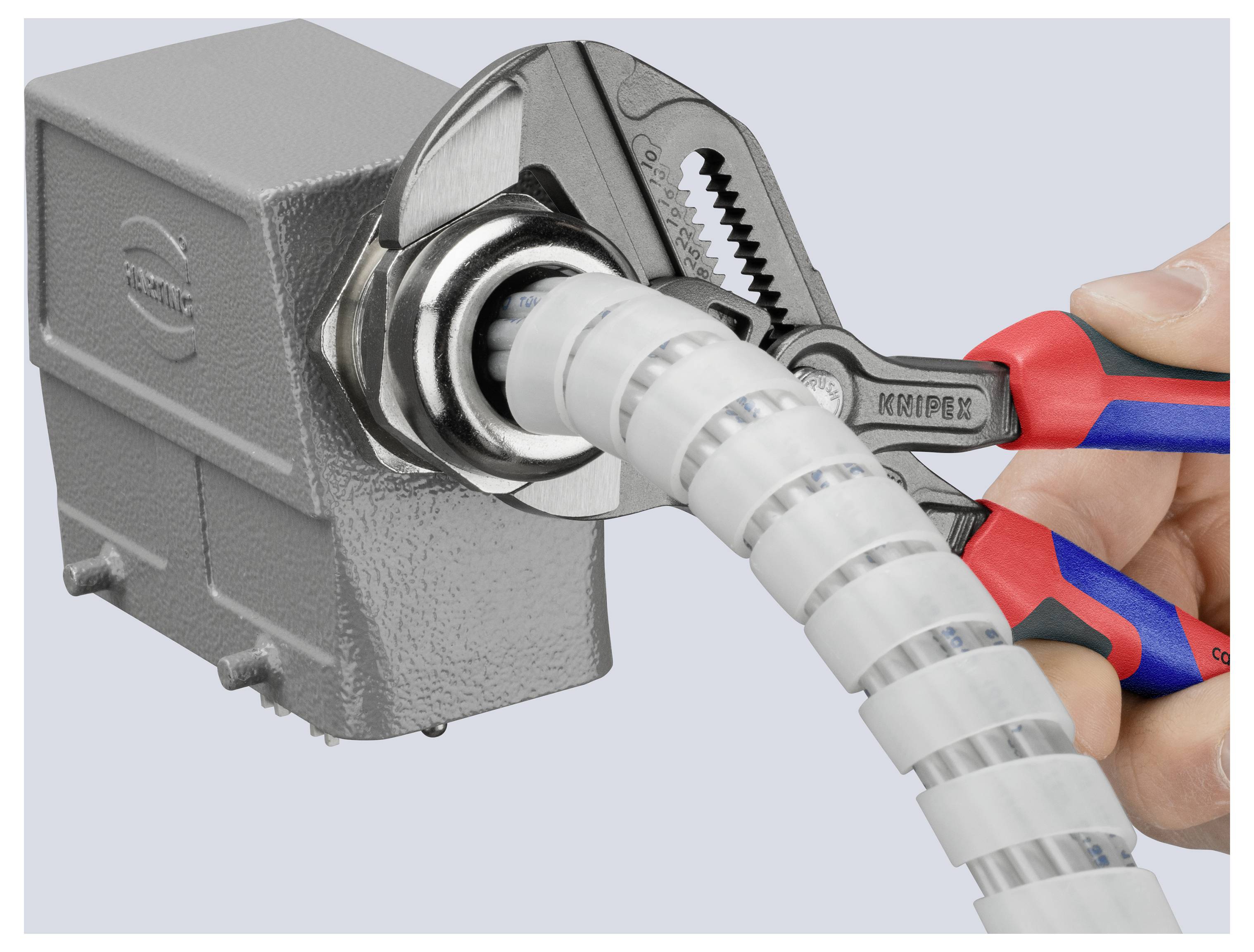 Ein Schraubenschlüssel zieht einen Verbinder um einen aufgewickelten Leitungsschutz fest, der an einer elektrischen Schaltkasten angebracht ist, und demonstriert ein sicheres Installationsverfahren.