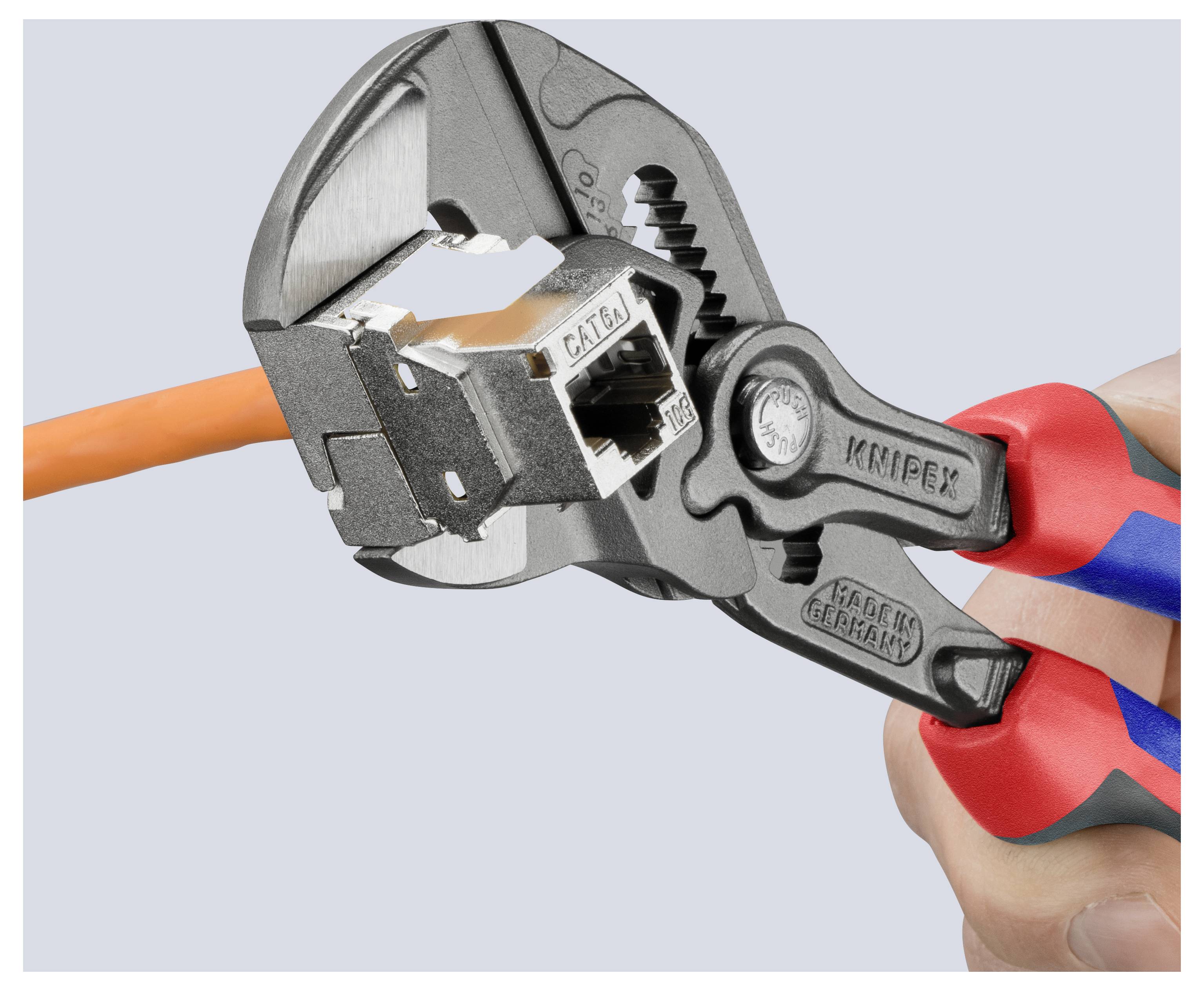 Eine Hand hält eine Zange, die ein orangefarbenes Kabel mit der Aufschrift 