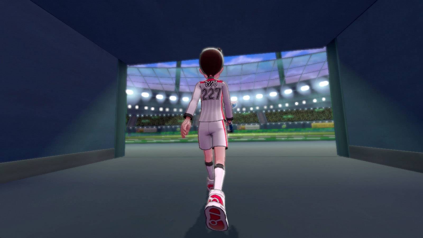 Eine Person in Sportkleidung mit der Nummer '227' betritt ein hell erleuchtetes Stadion durch einen Tunnel, gefüllt mit Zuschauern.