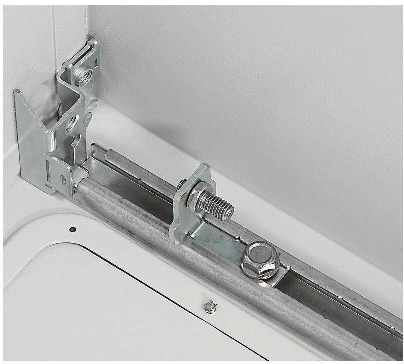 Metallverbindung mit Schraube und Mutter an einer Ecke einer weißen Metallstruktur, zeigt präzise Befestigungsmethode.