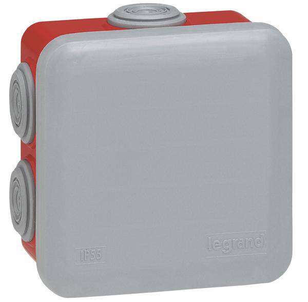 Eine graue, quadratische elektrische Abzweigdose der Marke Legrand, mit rotem Hintergrund und Kabeldurchführungen, Schutzart IP55.