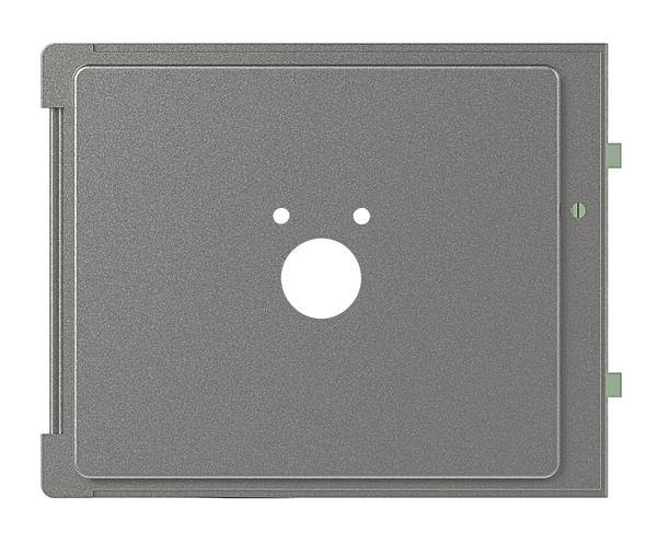 Ein graues Metallpaneel mit drei runden Löchern: eine große in der Mitte und zwei kleine oben, möglicherweise Teil eines elektrischen oder mechanischen Geräts.