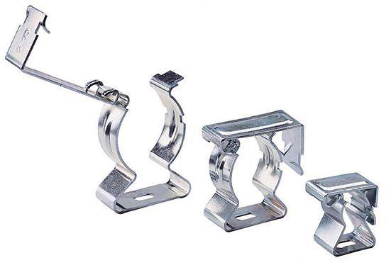 Verschiedene metallische Kabelhalter unterschiedlicher Größe und Form, die zur Befestigung von Kabeln an Wänden oder Decken verwendet werden.