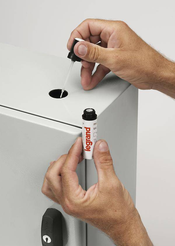 Zwei Hände bedienen ein Behälter mit einer Pipette und einem kleinen Röhrchen, möglicherweise zur Wartung oder Befüllung eines Geräts.