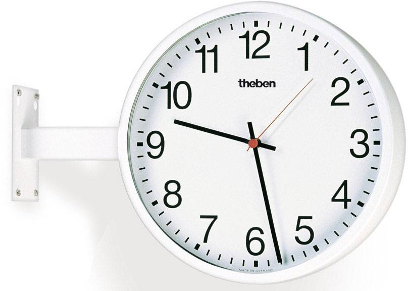 Eine weiße Wanduhr mit klaren schwarzen Zahlen und einem roten Sekundenzeiger zeigt 10:10 Uhr an. Sie ist an einer Halterung befestigt.