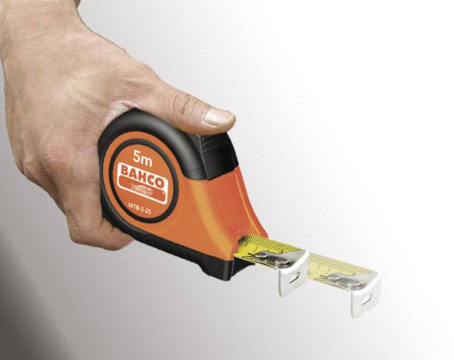 Eine Hand hält ein 5 Meter langes Maßband der Marke Bahco. Das Maßband ist teilweise ausgezogen.