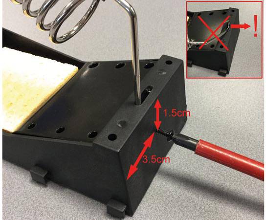 Lötkolbenhalter mit Schraubenzieher zeigt, wie eine Schraube entfernt wird. Rotes 'X' im Bildausschnitt zeigt falsche Anordnung.