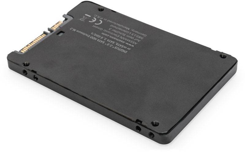Eine schwarze SSD-Festplatte mit SATA-Anschluss, liegend auf einer weißen Oberfläche.