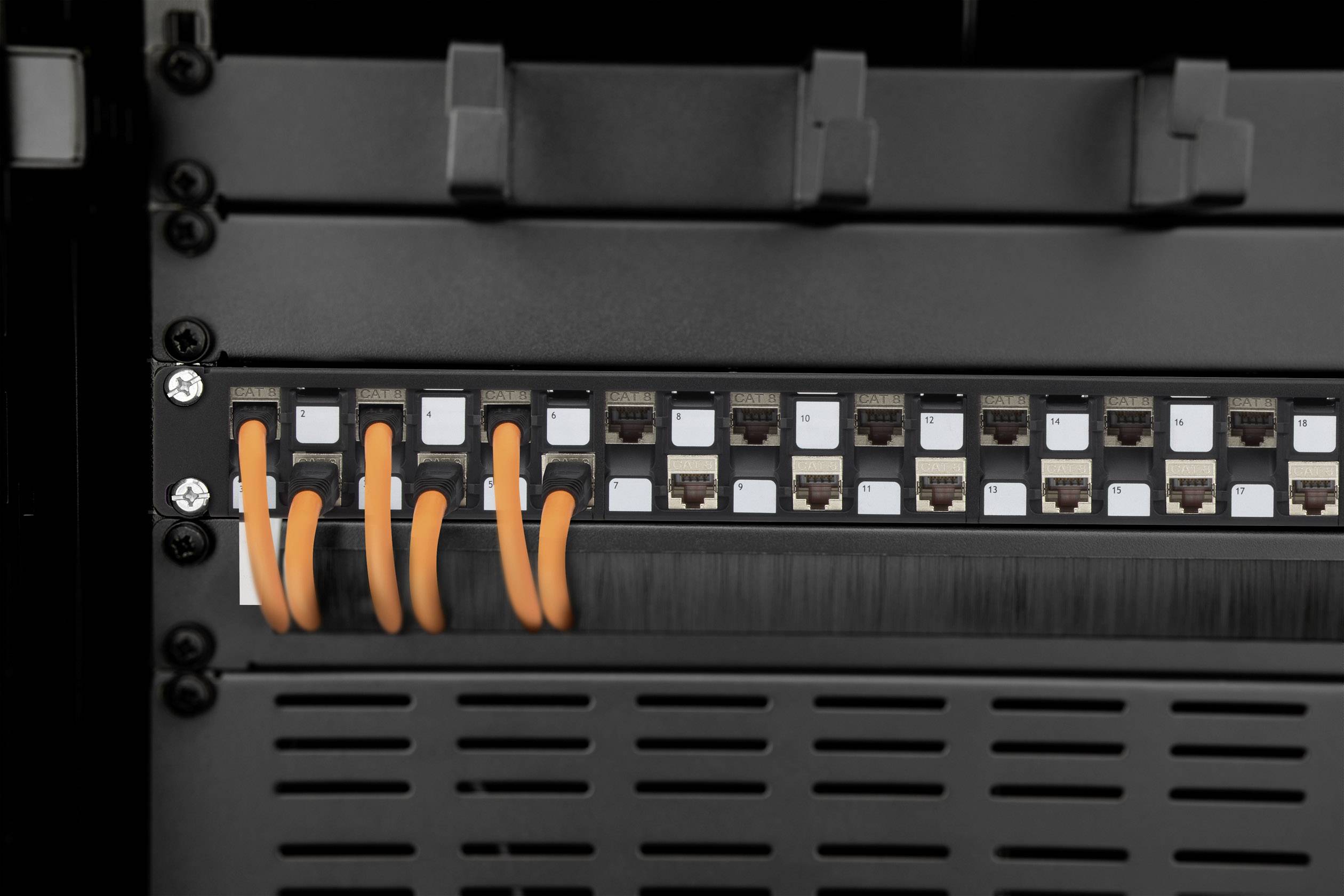Ein Patchpanel mit mehreren Ethernet-Anschlüssen. Sechs orangefarbene Kabel sind an einigen der Ports angeschlossen.
