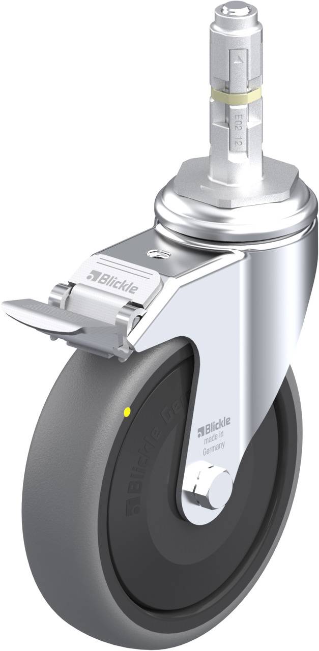 Rollstuhlrad mit Bremse, Metallaufhängung und schwarzem Gummi. Silberne Metallteile glänzend. Markenname 'Blickle' auf der Aufhängung.