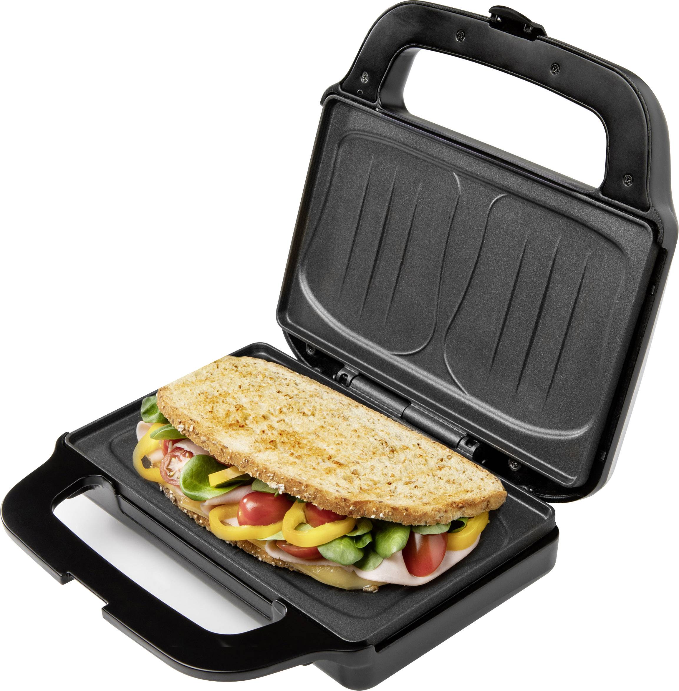 Sandwich mit Gemüse und Wurst in einem offenen Sandwichmaker. Brot ist goldbraun geröstet. Gerät auf schwarzer Oberfläche.