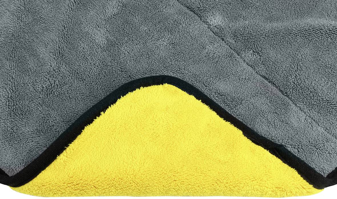 Graues Handtuch aus weichem Material, Ecke umgeschlagen, zeigt eine gelbe Innenseite.