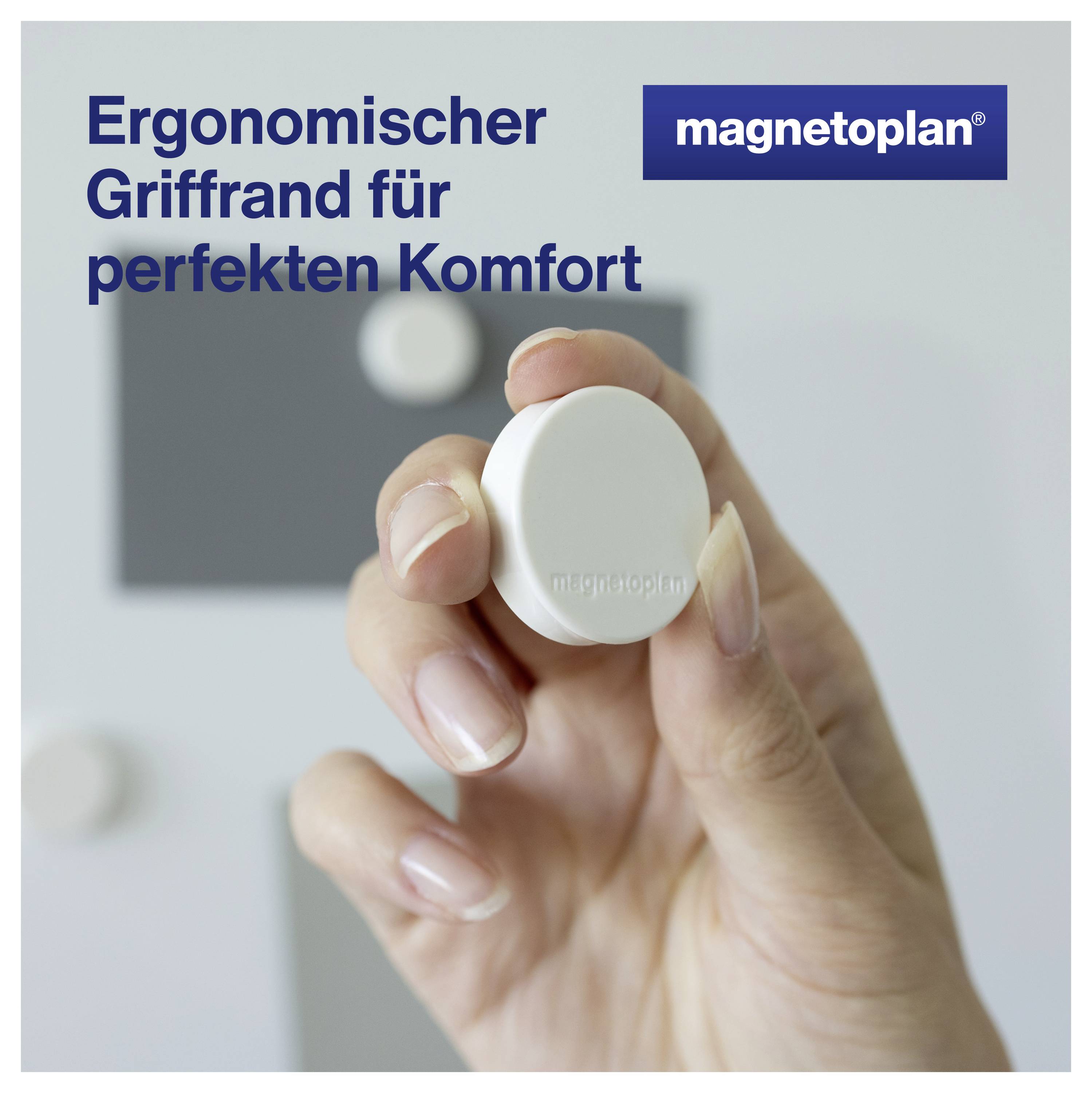 Eine Hand hält einen ergonomisch geformten, weißen Magneten vor einem grauen Hintergrund. Text: 'Ergonomischer Griffrand für perfekten Komfort'.