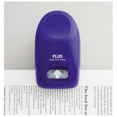 Ein blauer, klammerloser Hefter steht auf einem Papier. Aufschrift des Hefters: 'PLUS Staple-Free Stapler'.