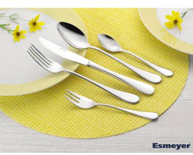 Besteckset bestehend aus Messer, Gabel, großer Löffel, kleiner Löffel und Kuchengabel, auf einem gelben Platzset arrangiert.