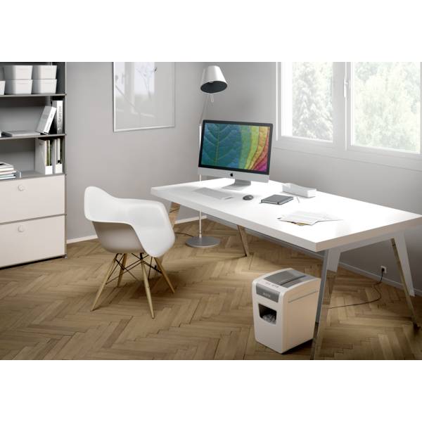 Ein modernes Büro mit einem Schreibtisch, auf dem sich ein Computer mit buntem Bildschirm, eine Lampe, Bücher und ein Stuhl befinden.