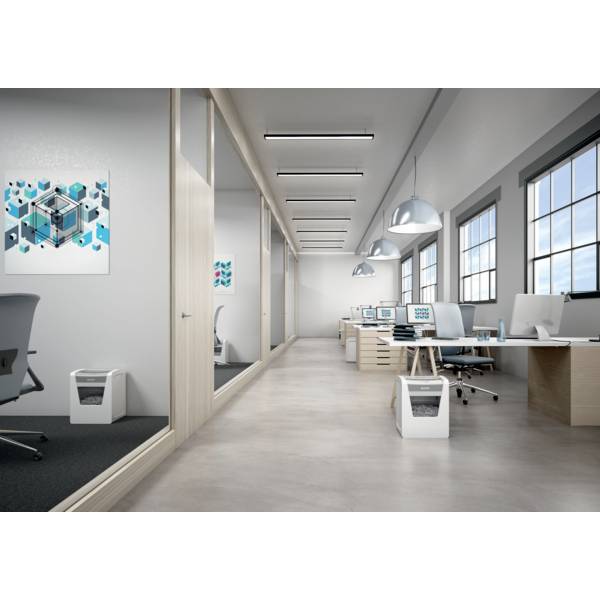 Moderne Büroumgebung mit mehreren Schreibtischen, Computern und Hängelampen. An den Wänden hängen abstrakte Kunstwerke.