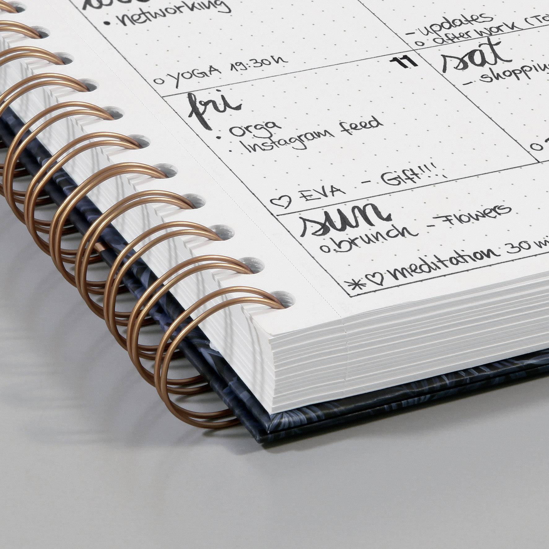 Offener Terminplaner mit handschriftlichen Notizen für verschiedene tägliche Aktivitäten wie Yoga, Einkaufen und Mittagessen.