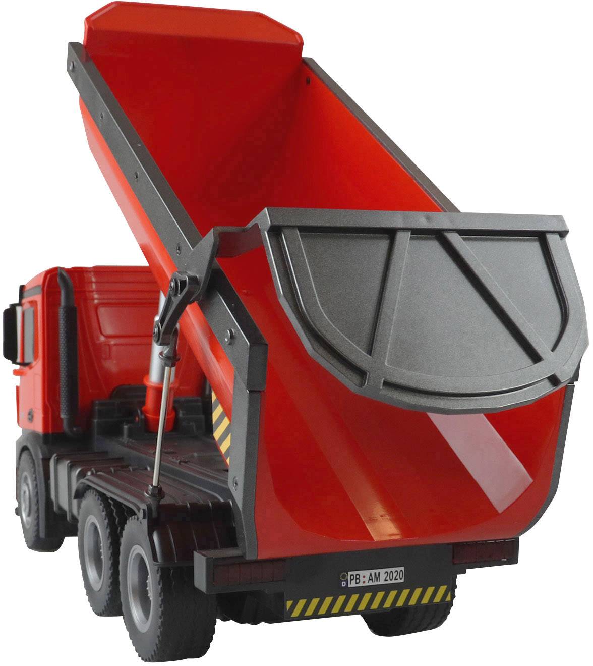 Ein rotes Spielzeug-Kipplastwagen mit geöffnetem Kippbehälter ist in seitlicher Perspektive zu sehen.