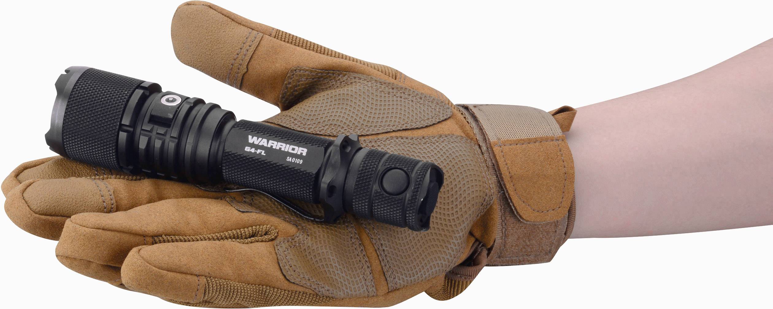 Eine Hand in einem braunen Handschuh hält eine schwarze Taschenlampe mit der Aufschrift 'WARRIOR'.