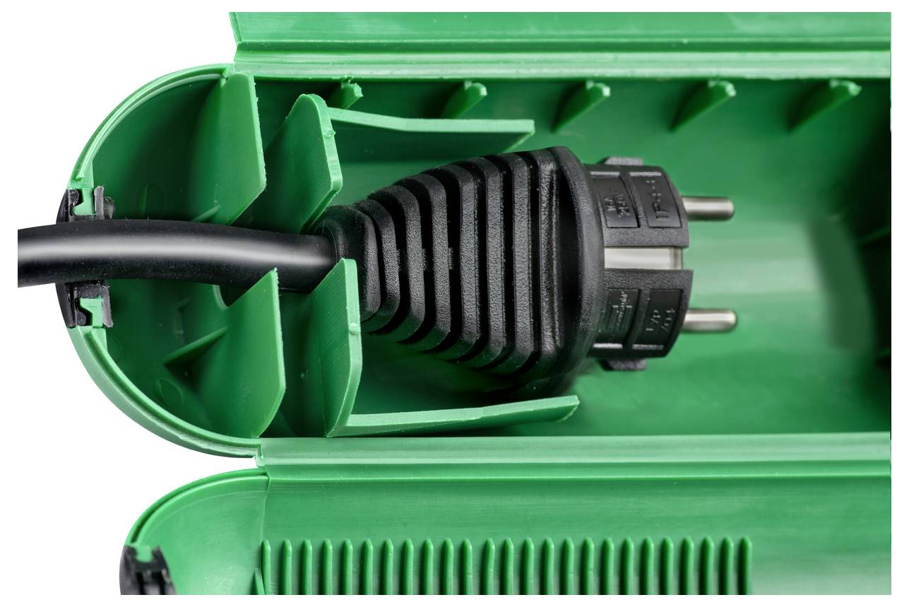 Nahaufnahme eines grünen Kunststoffgehäuses eines elektrischen Geräts, das ein schwarzes Stromkabel zeigt, das durch eine Zugentlastung in das Gehäuse eindringt.