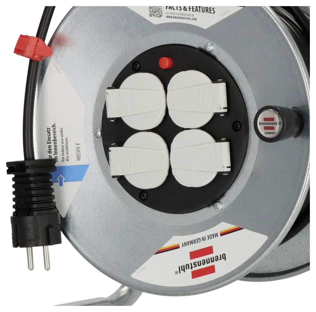 Nahaufnahme einer runden elektrischen Kabelrolle mit vier abgedeckten Steckdosen, einem Stromkabel mit Stecker und einem roten Ein-/Ausschalter.