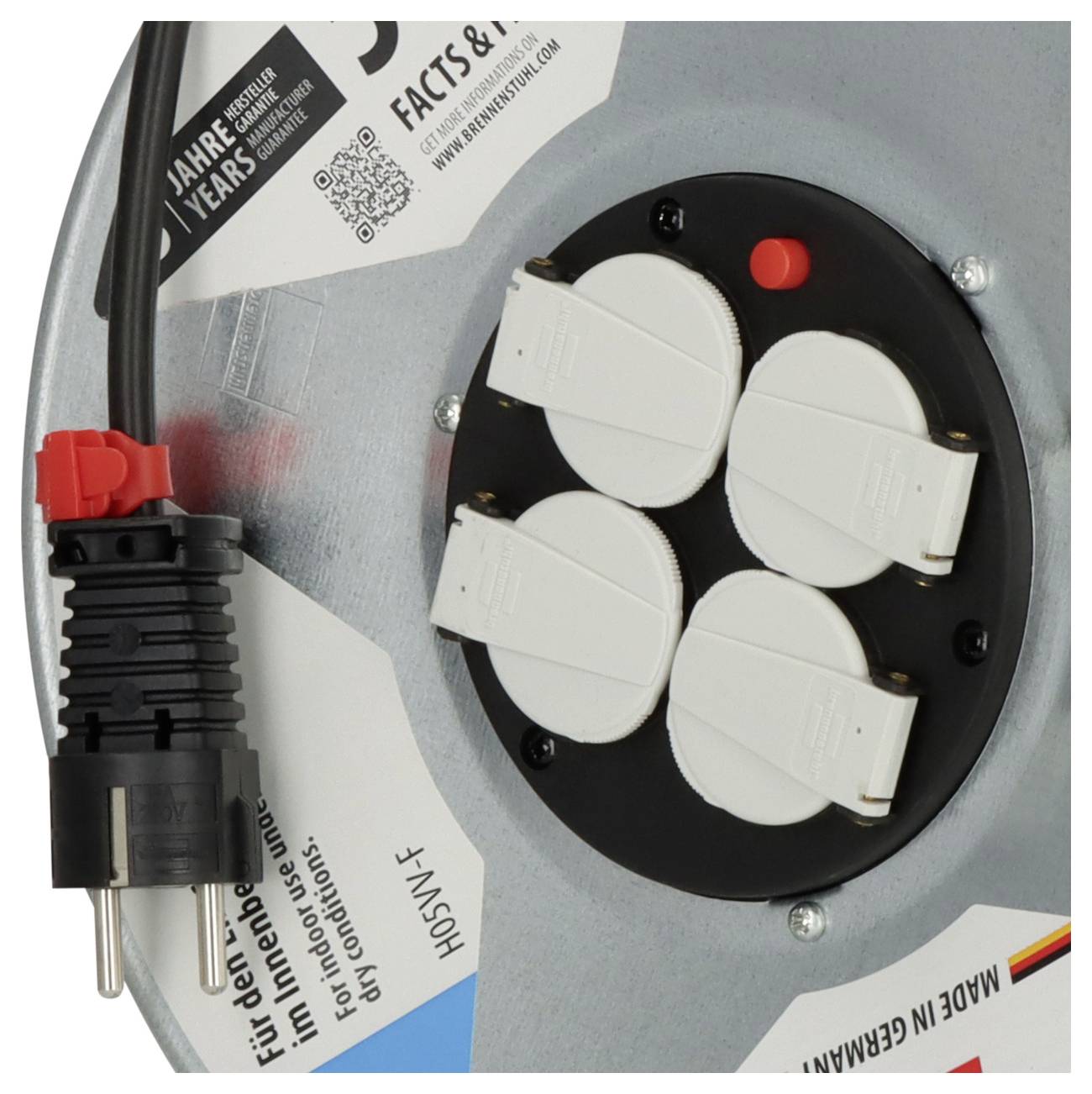 Nahaufnahme eines deutschen Steckdosenpanels mit vier abgedeckten Steckdosen, einem Kabelstecker und Produktetiketten auf einer Metalloberfläche.