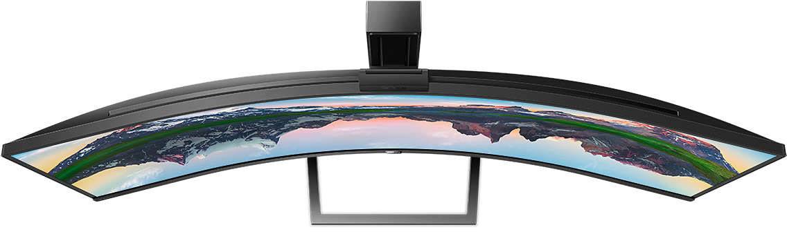 Gebogener Ultrawide-Monitor von oben, zeigt ein farbenfrohes Panorama einer Berglandschaft bei Sonnenuntergang.