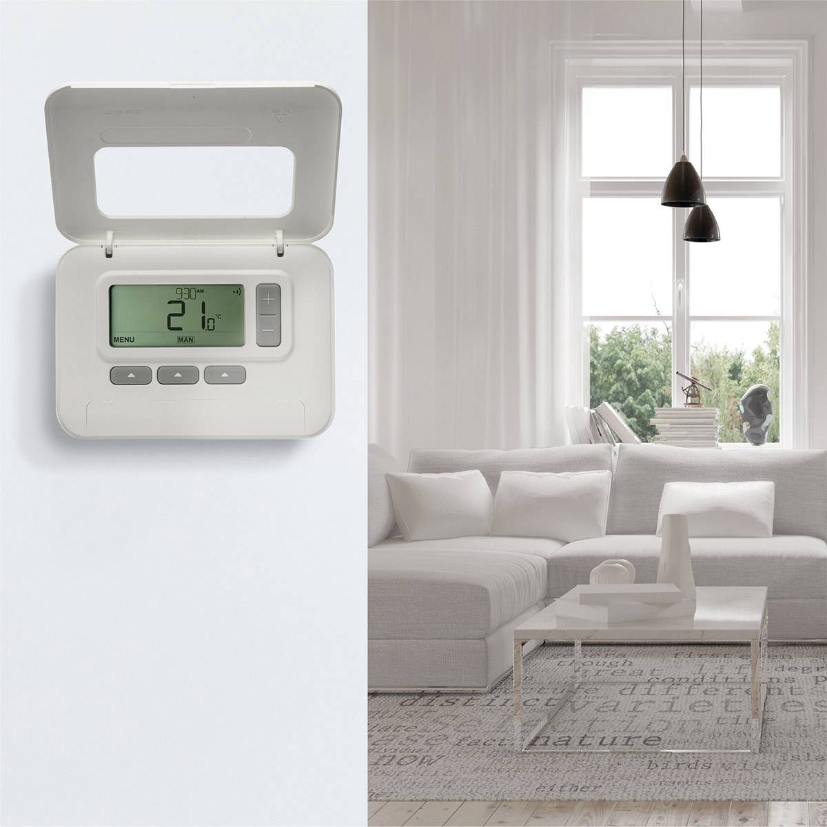 Ein Thermostat an der Wand zeigt '21°C'. Im Hintergrund ein modernes Wohnzimmer mit einem großen Fenster und weißen Sofas.