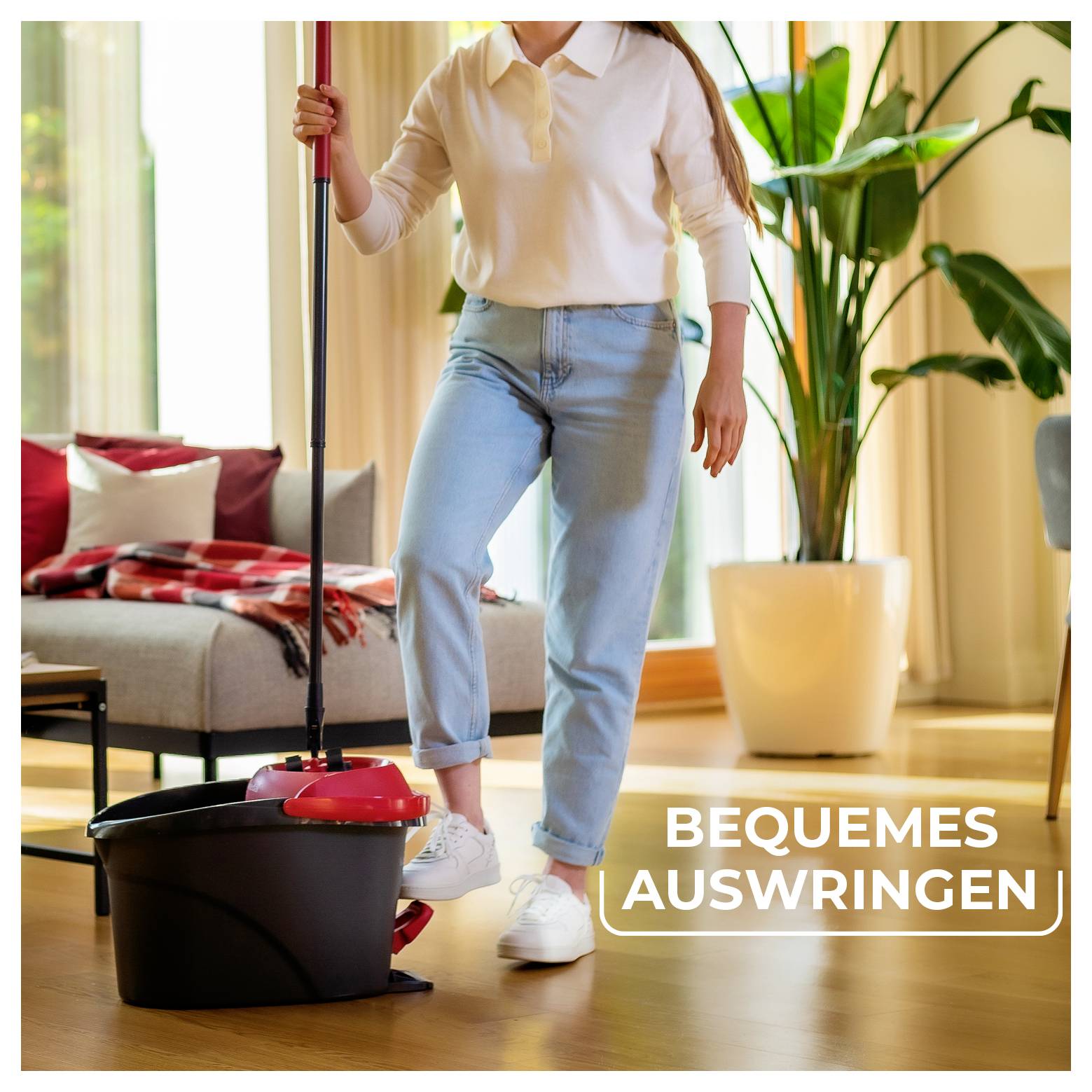 Person wischt einen Wohnzimmerboden mit einem Eimer; Text lautet „BEQUEMES AUSWRINGEN