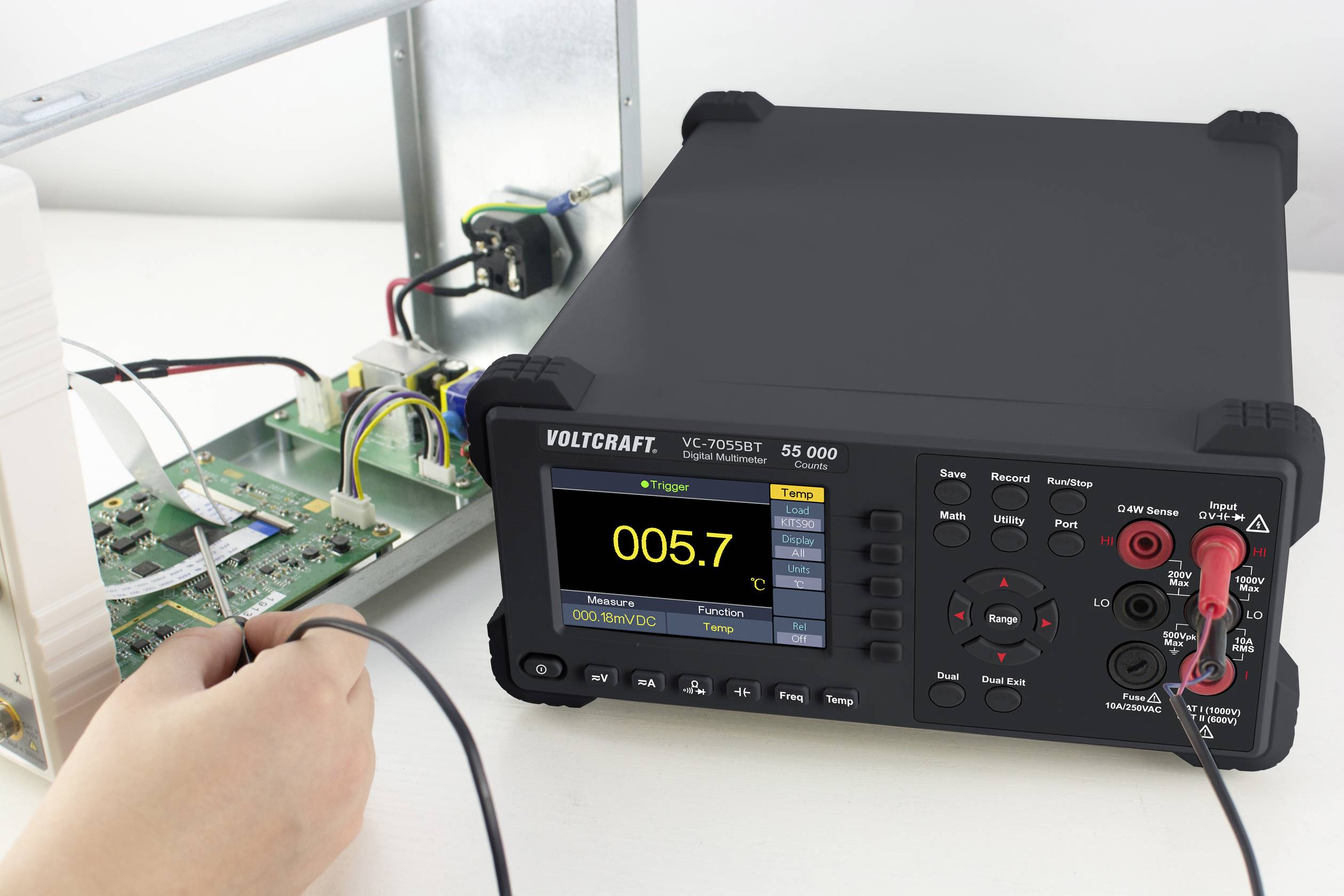 Messgerät von VOLTCRAFT, Modell VC7055BT, zeigt einen Wert von 0,05 V an. Es ist mit einer Leiterplatte verbunden. Eine Hand hält die Messleitung.