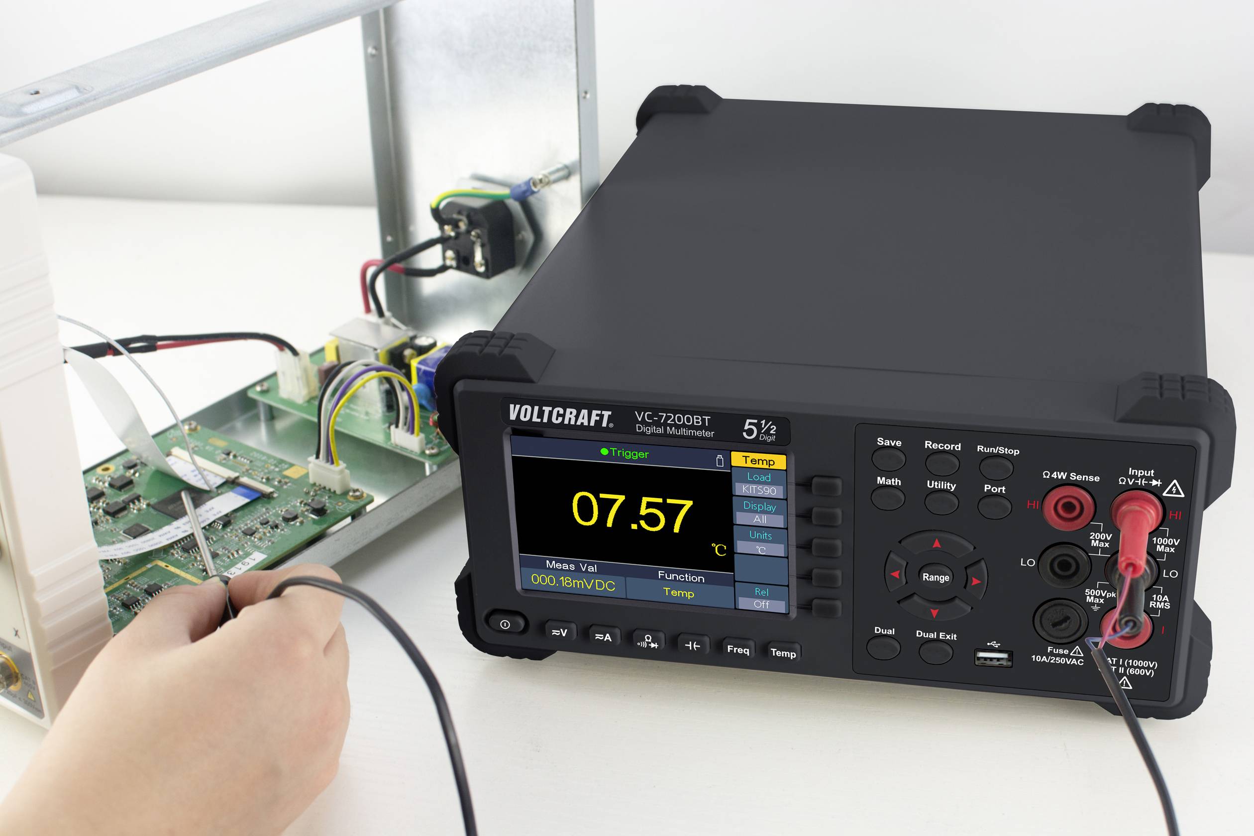 Multimeter, das 9,57 V anzeigt, wird verwendet, um die Spannung auf einer elektronischen Schaltung zu messen, die auf einem Tisch liegt.