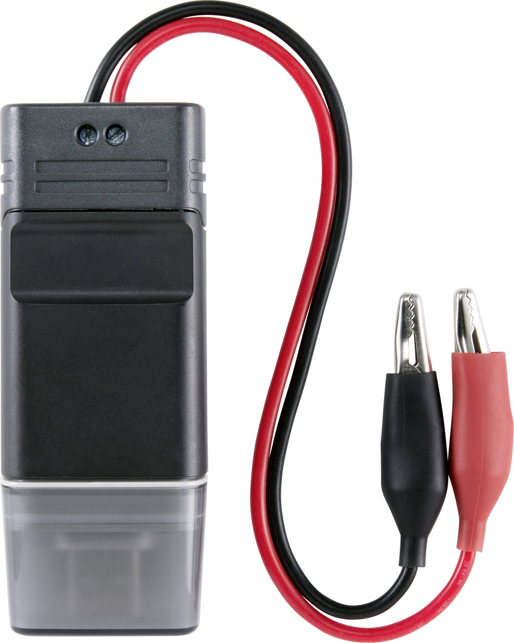 Gerät mit Batterie, schwarzem Gehäuse und rotem sowie schwarzem Kabel mit Krokodilklemmen. Verwendet zur Spannungstestung.