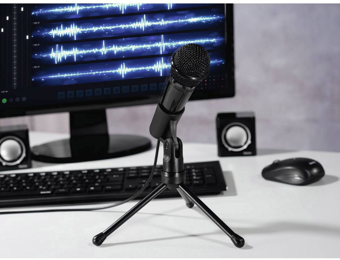 Mikrofon vor einem Monitor mit Audiowellenformen und Lautsprechern; zeigt Aufnahme- oder Bearbeitungsumgebung für Audio.