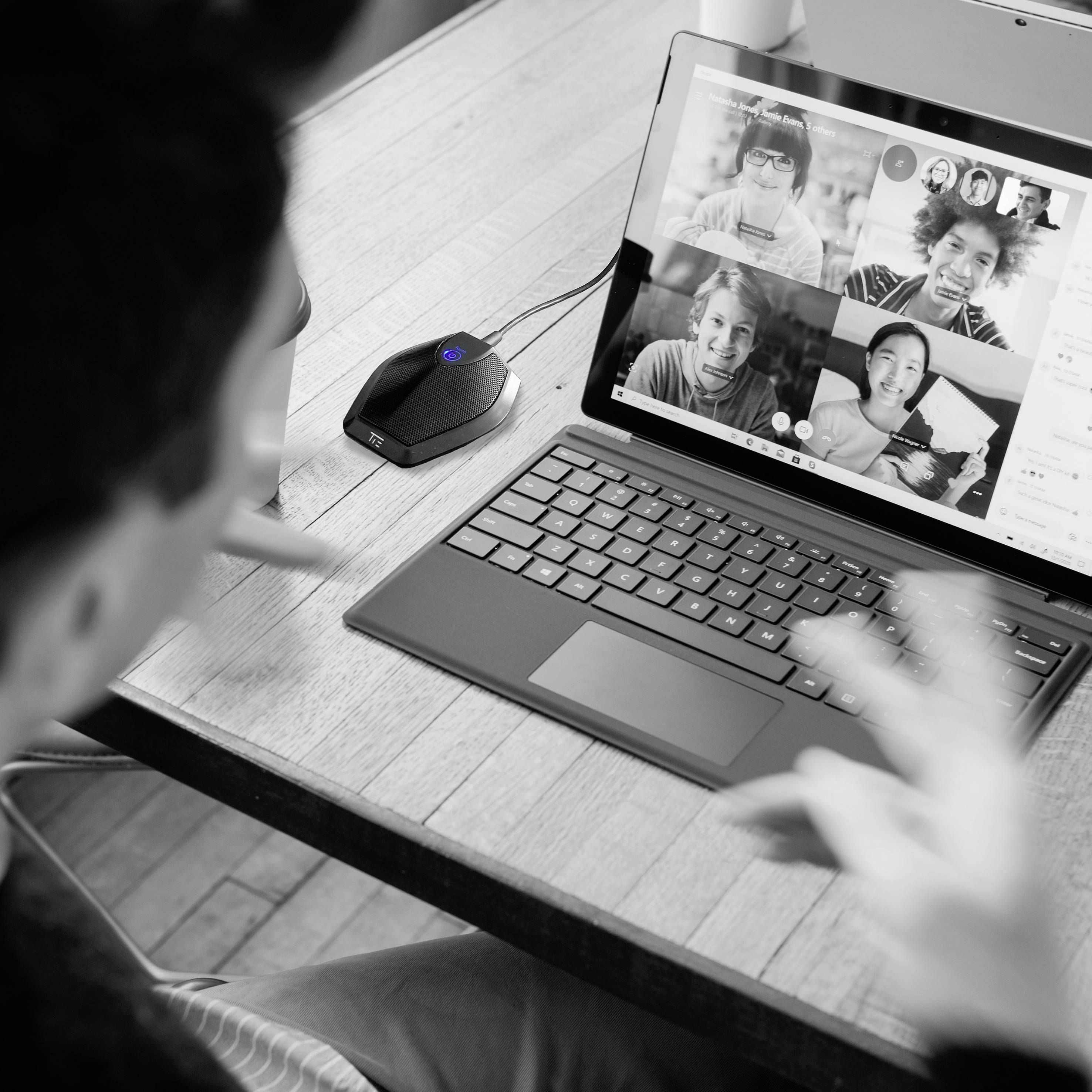 Eine Person nimmt an einer Videokonferenz mit mehreren Teilnehmern teil, die auf dem Laptop-Bildschirm sichtbar sind.