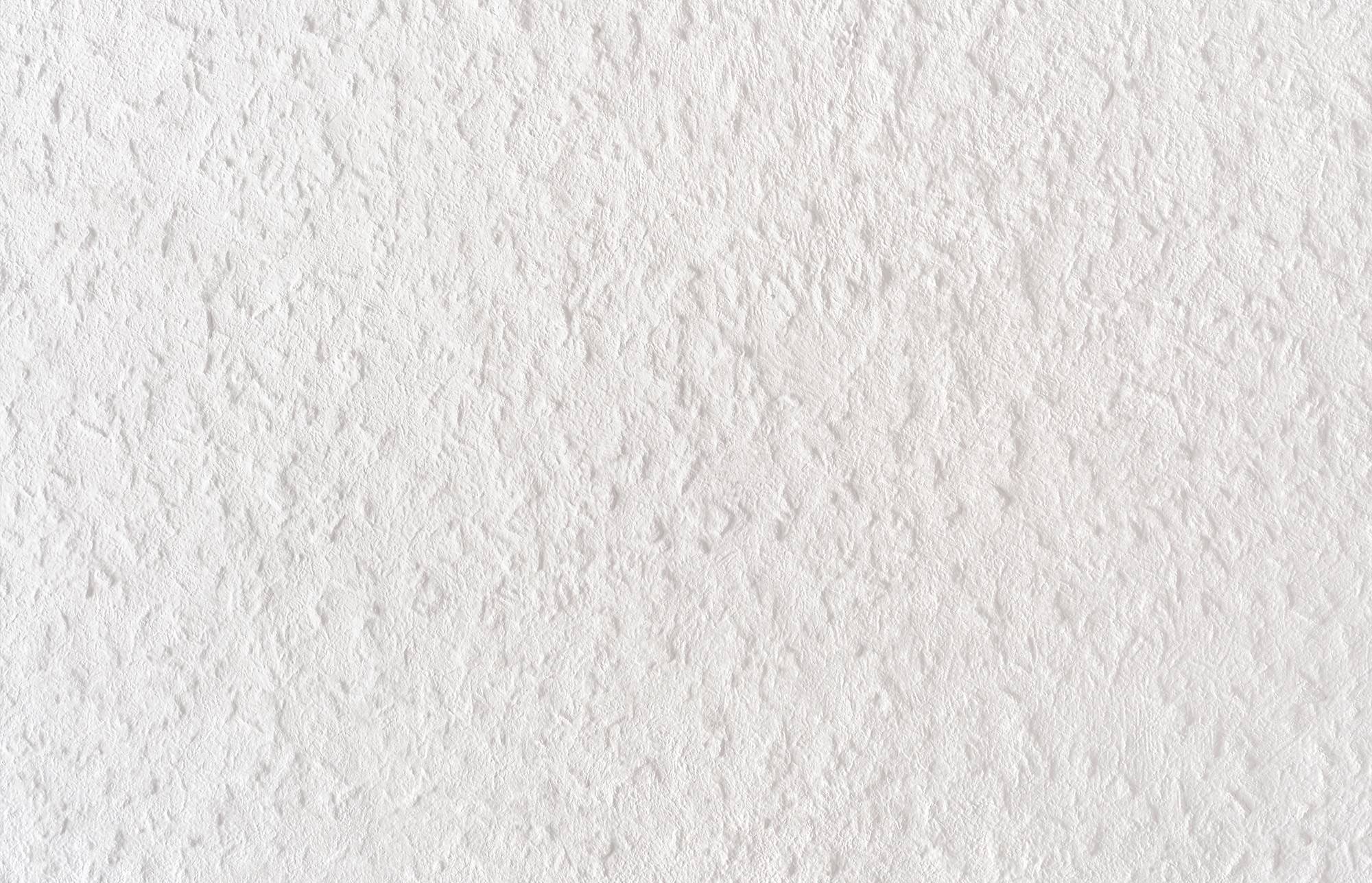 Nahaufnahme einer weißen strukturierten Wand oder Papierfläche mit feinem geprägtem Muster und Schatten.