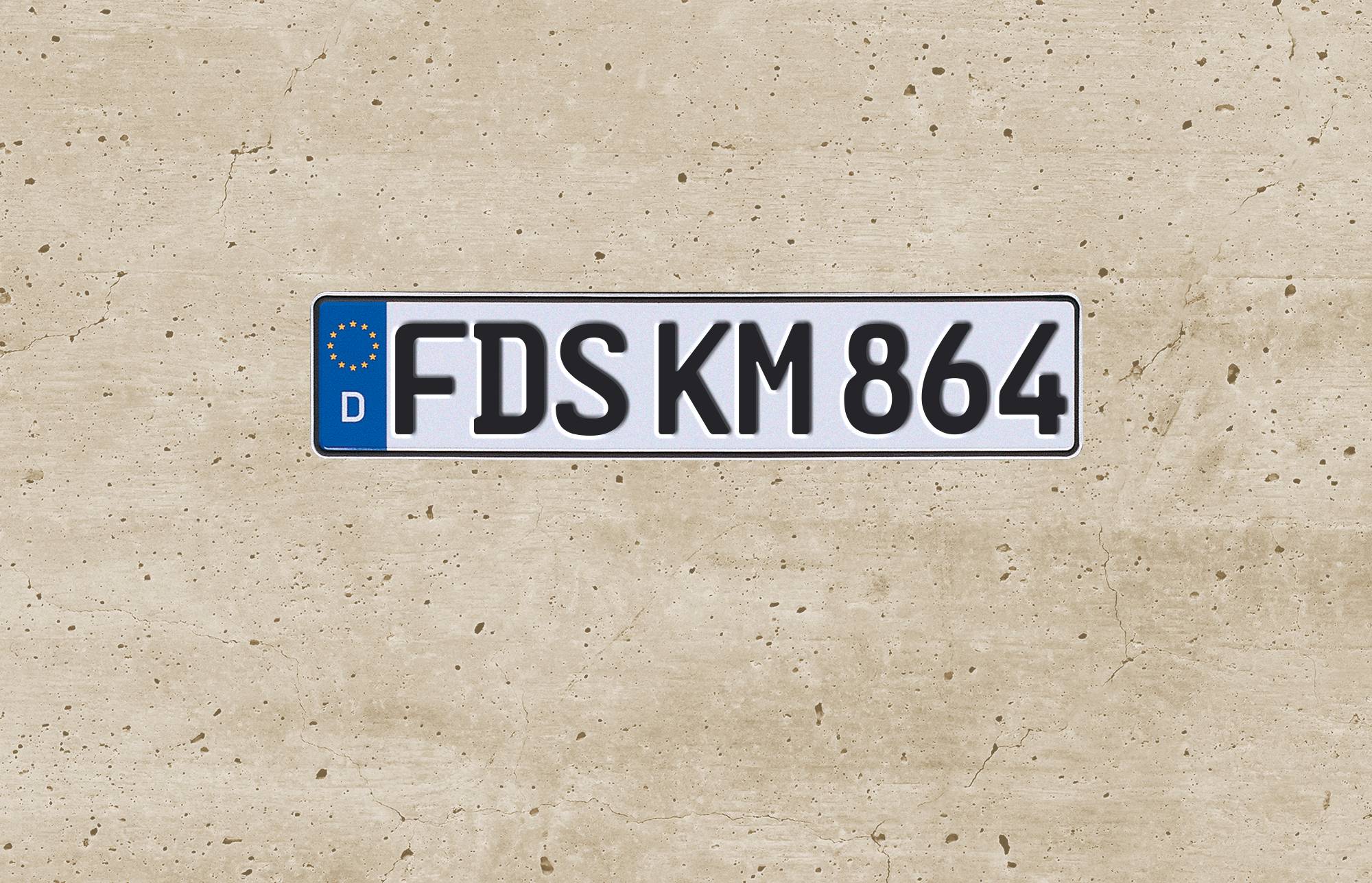 Deutsches Kennzeichen mit der Aufschrift "FDS KM 864" auf einfachem beigefarbenem Hintergrund.