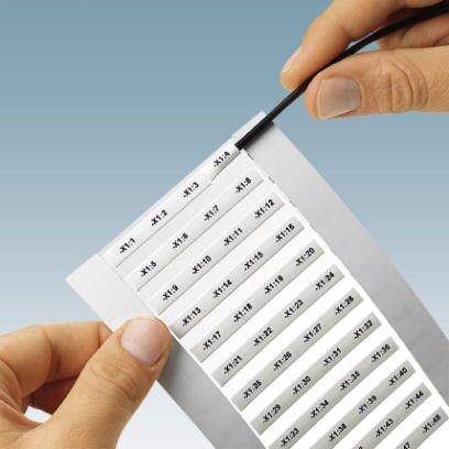 Zwei Hände halten ein Blatt mit nummerierten Klebeetiketten. Die Etiketten zeigen fortlaufende Nummern von #111 bis #122.