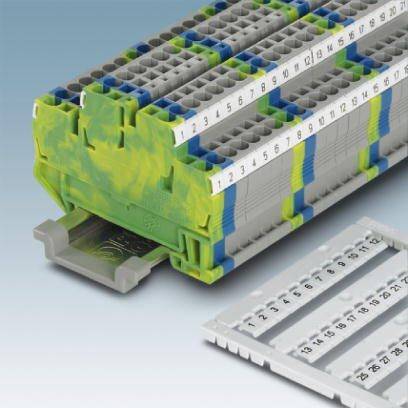 Eine graue und grüne Klemmeinheit mit nummerierten Anschlüssen, vermutlich für elektrische Schaltkreise, liegt auf einer Oberfläche.