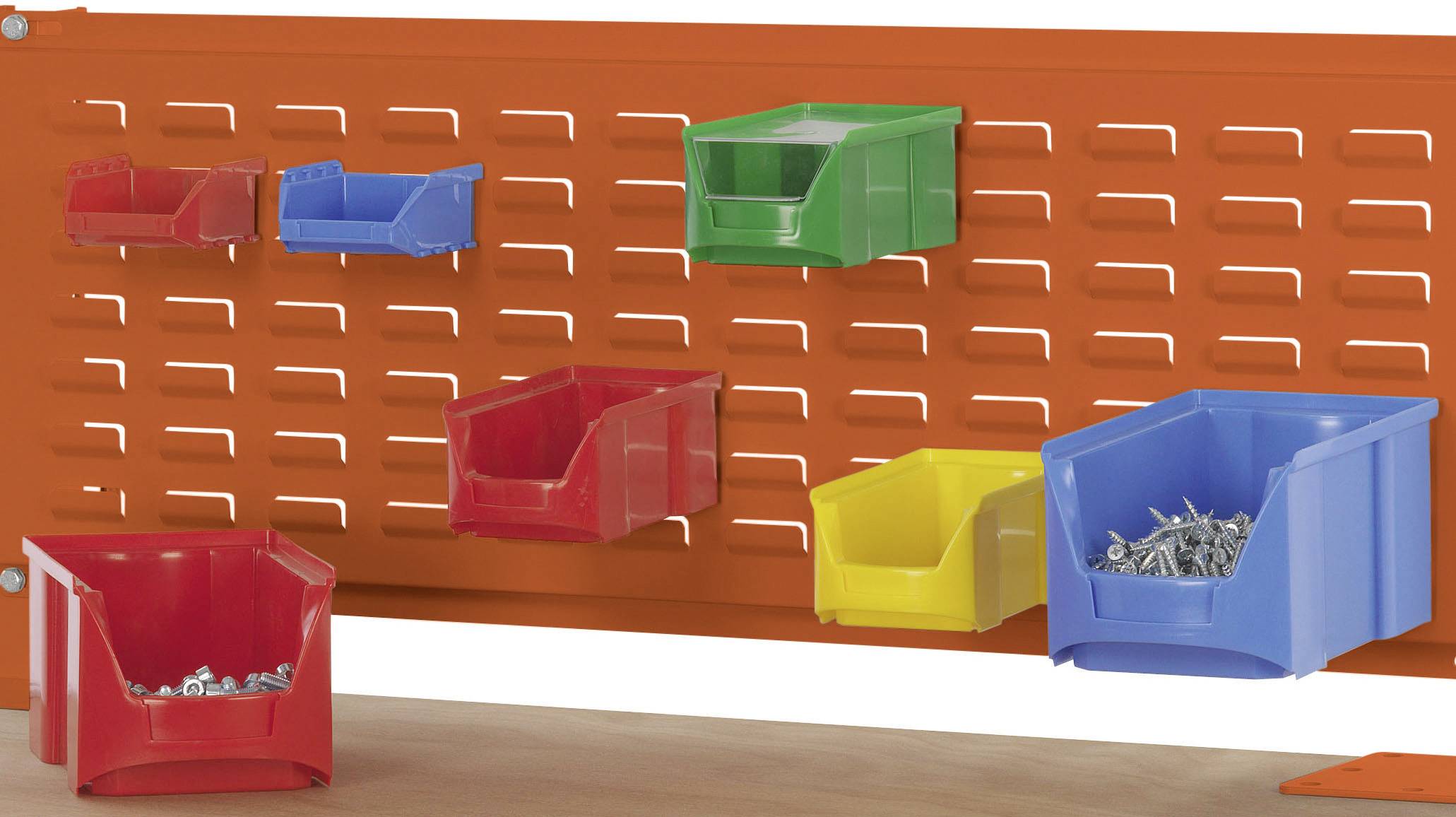 Orangefarbene Lochwand mit farbigen Kunststoffkästen in Rot, Blau, Gelb und Grün, gefüllt mit kleinen Metallteilen.