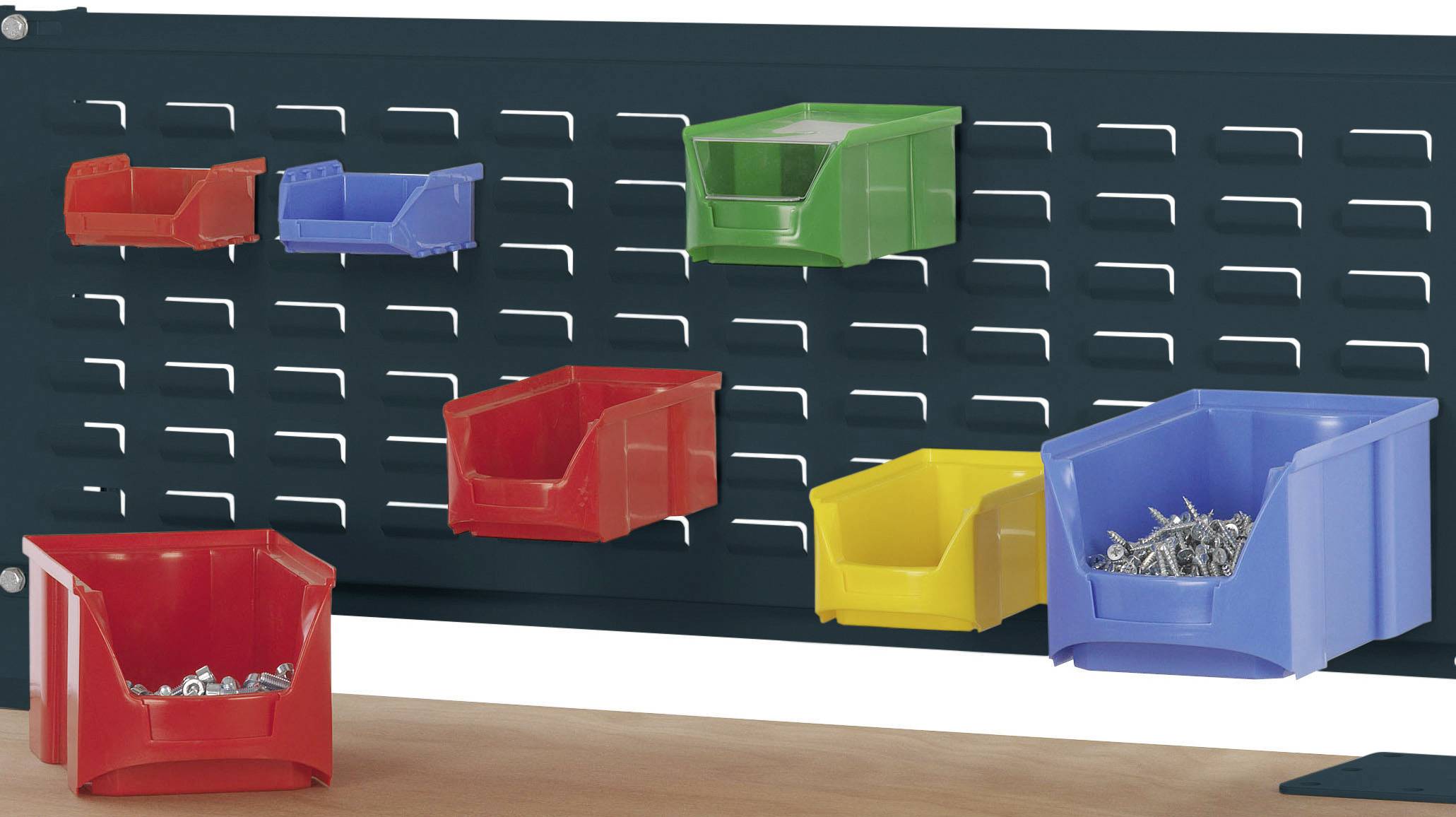 Mehrere farbige Aufbewahrungsboxen sind an einer Lochwand befestigt. Einige Boxen enthalten Schrauben und Nägel.