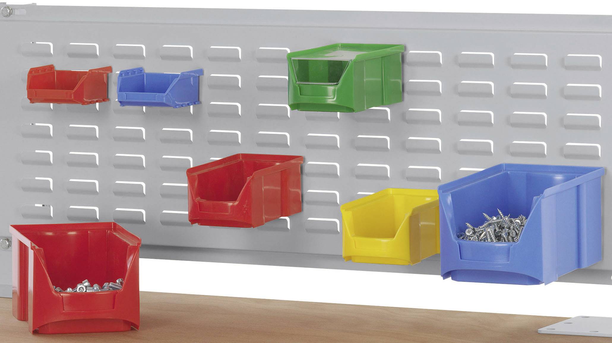 Eine graue Lochwand mit bunten Kunststoffkästen in Rot, Blau, Gelb und Grün. Einige Kästen enthalten Schrauben. Ideal zur Werkstattorganisation.