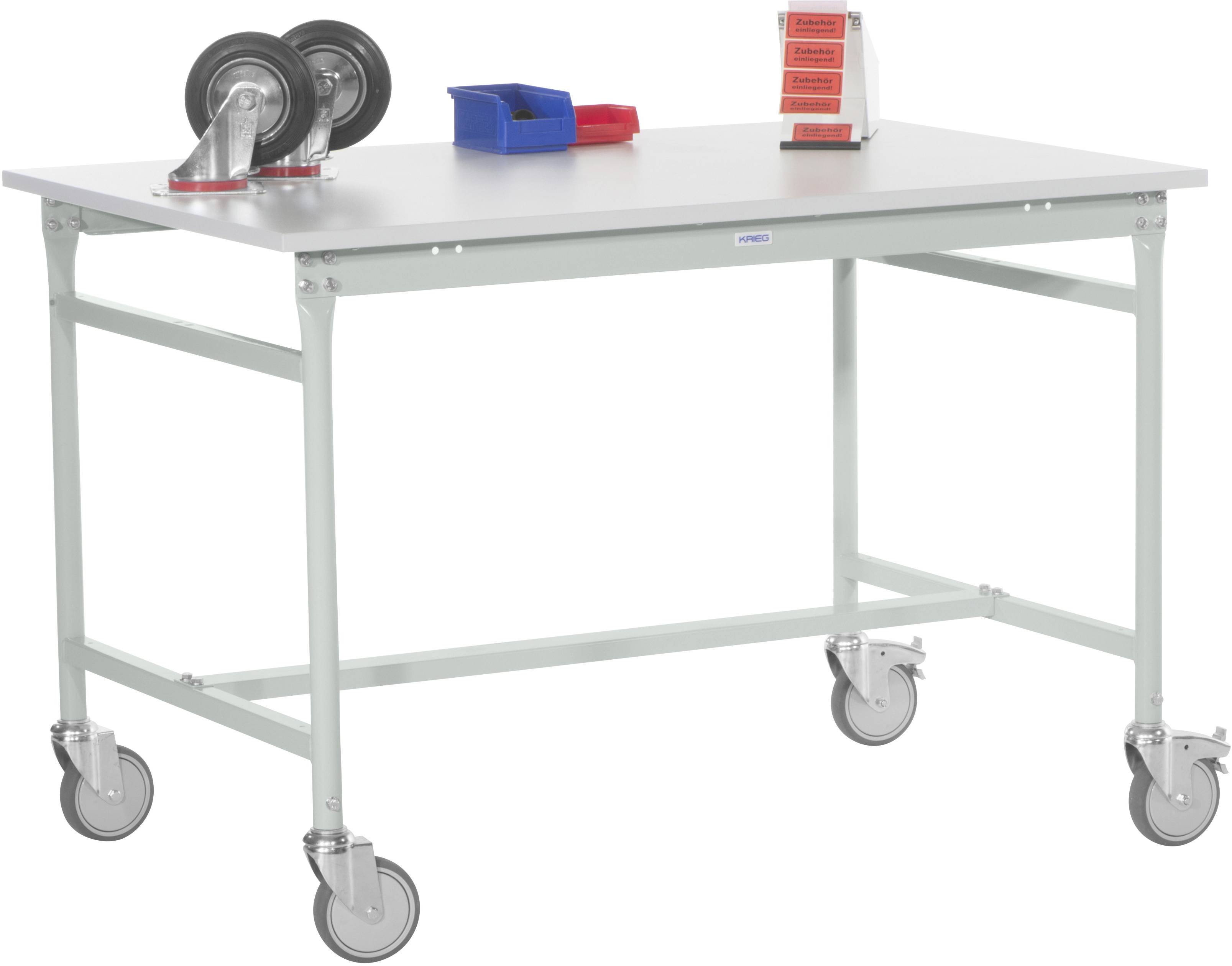 Weißer Arbeitstisch mit vier Rollfüßen. Auf dem Tisch sind zwei Räder, eine blaue Box, rote Teile und ein Aufsteller.
