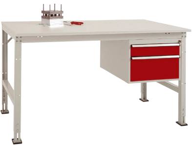 Ein weißer Arbeitstisch mit roter Schublade auf der rechten Seite; auf dem Tisch liegen ein Werkzeug und ein Metallstück.