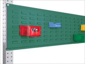 Eine grüne Werkzeugwand mit farbigen Aufbewahrungsboxen in Rot, Blau, Grün und Gelb, befestigt an einer metallenen Trägerstruktur.