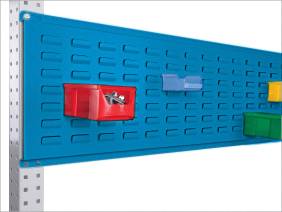 Blaues Lochblech an einer Wand mit farbigen Aufbewahrungsboxen: Rot, Blau, Grün. Enthält Kleinteile wie Schrauben.