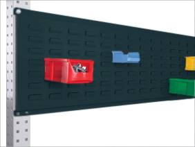 Schwarzes Lochbrett an einer Wand mit mehreren kleinen, bunten Aufbewahrungsboxen; rote Box enthält Schrauben.
