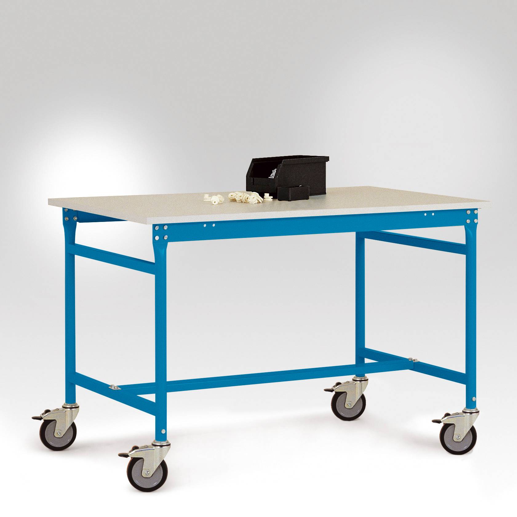 Ein blauer, beweglicher Metalltisch mit vier Rädern. Auf der Tischplatte befinden sich Schrauben und eine kleine, schwarze Werkzeugkiste.