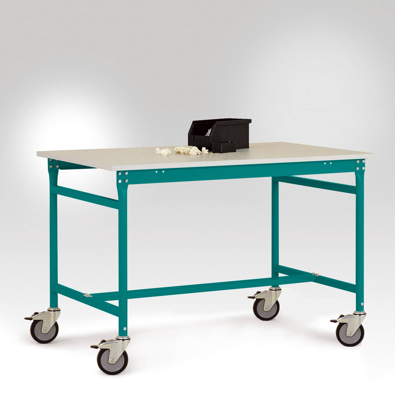 Ein mobiler, rechteckiger Tisch auf Rädern mit blauem Metallrahmen und hellem Tischblatt, darauf eine offene Werkzeugbox und weiße Kabel.