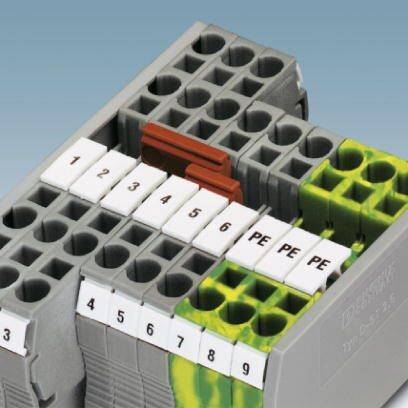 Graues elektrisches Steckverbindungselement mit nummerierten Anschlüssen von 1 bis PE, teilweise markiert in Gelb und Grün.